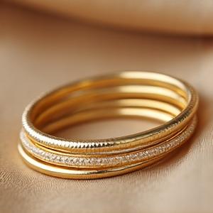 Fins bracelets et bagues en or empilables, récemment ajoutés à la sélection d'accessoires.