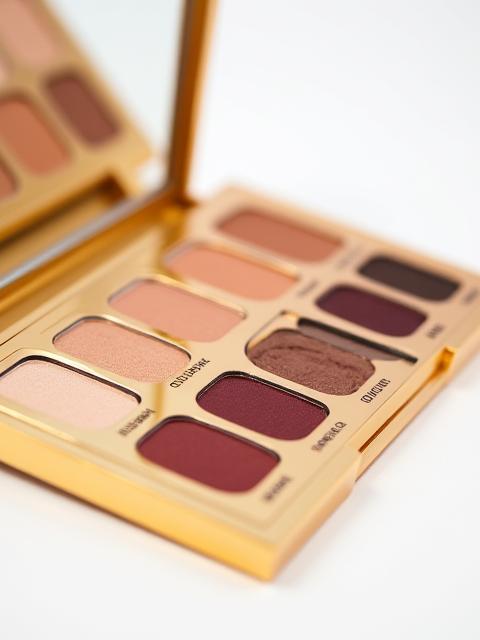 Palette de fards à paupières tons nude et marrons, boîtier élégant doré.